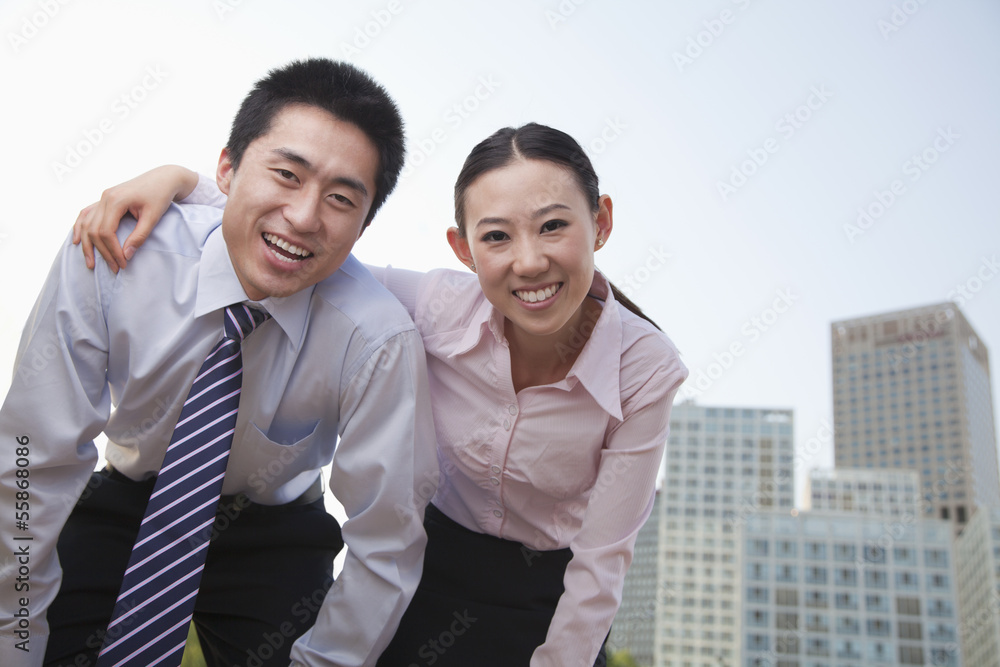 Portrait of two young business people leaning forward, outside in the business district, Beijing Portrait of two young business people leaning forward, outside in the business district, Beijing