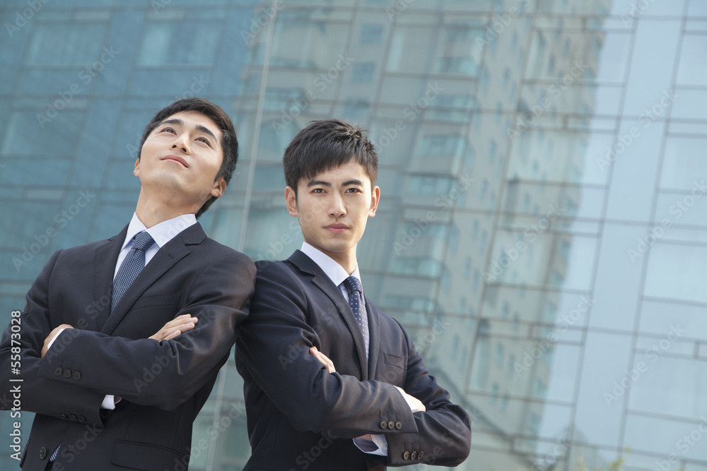 Two young businessmen outside glass building, portrait Two young businessmen outside glass building, portrait