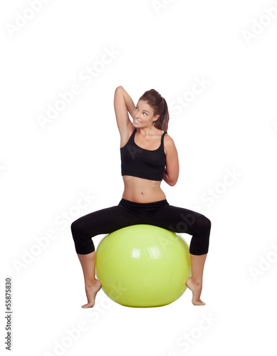Young beautiful woman sitting on a gymnastic ball stretching arm