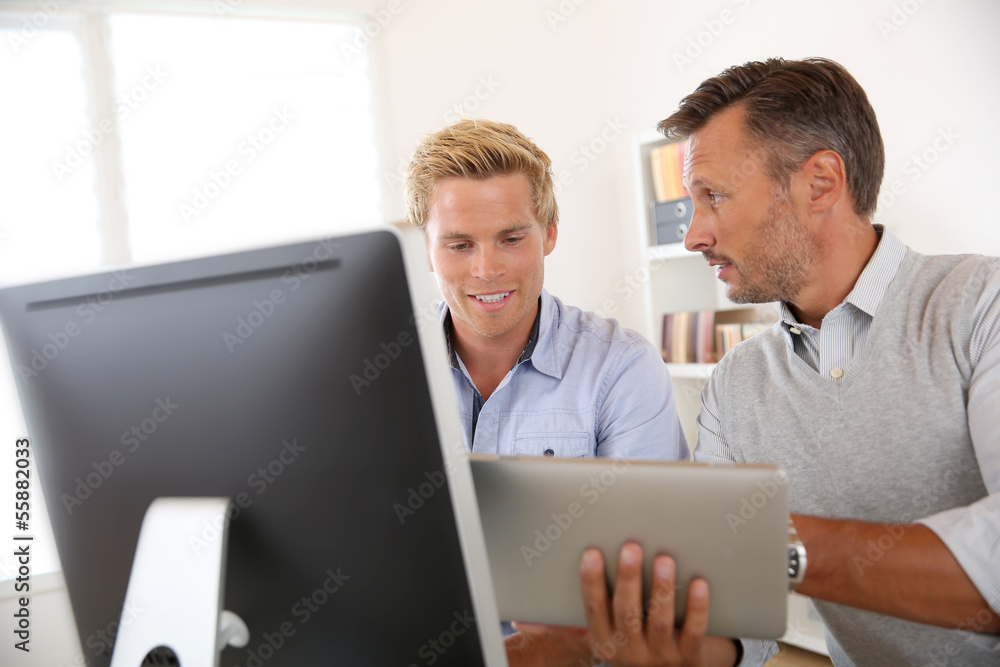 Manager with employee working in office Manager with employee working in office