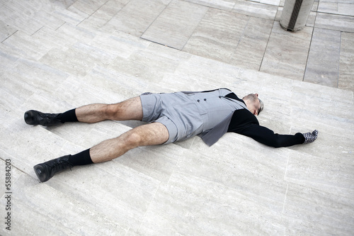 man wearing glasses in shorts laying on a staircase