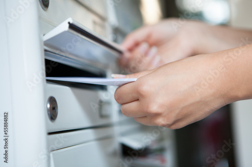Woman putting envelope in mailbox