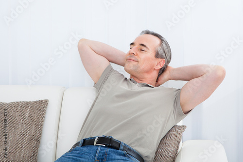 Happy Mature Man Relaxing On Sofa