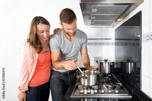 Fototapeta Naklejka Na Ścianę i Meble -  Couple Cooking A Meal On Stove