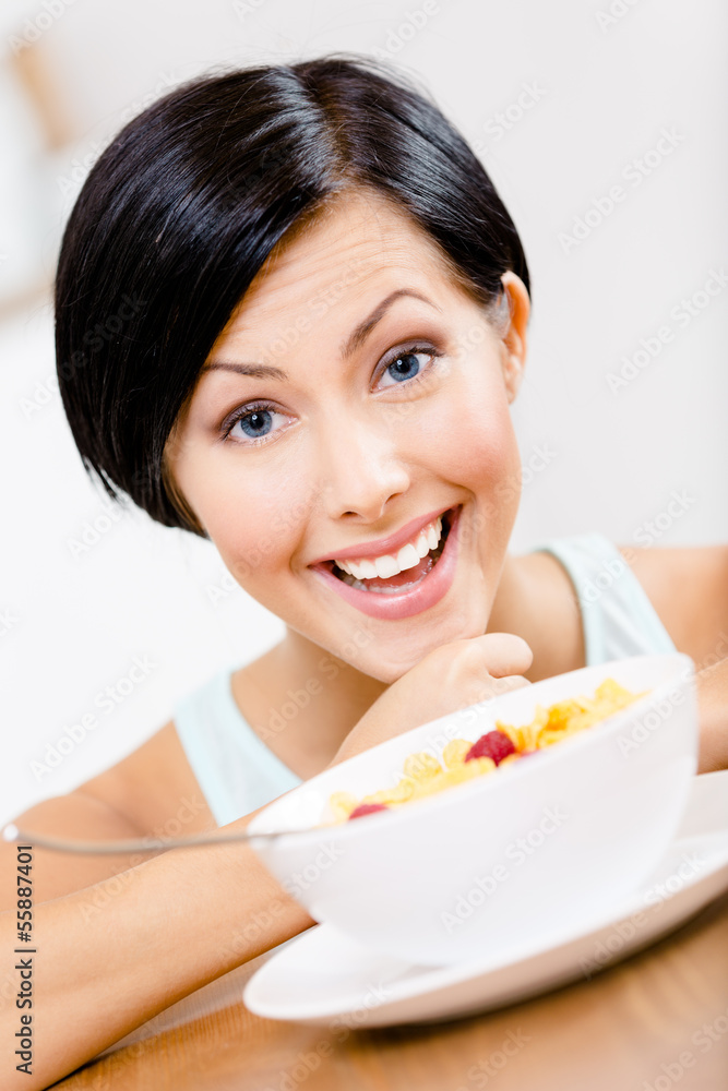 Close up of girl near the plate with cereals and strawberry Close up of girl near the plate with cereals and strawberry