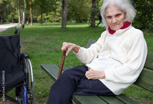 Alte Frau auf einer Parkbank photo