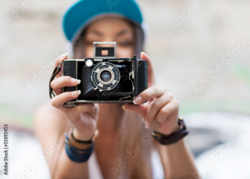 Young, beautiful woman with retro camera. Hipster style outdoor.