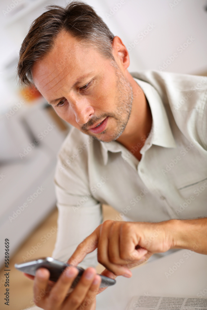 Smiling guy sending message with smartphone Smiling guy sending message with smartphone