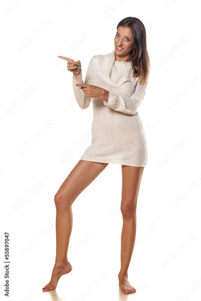 smiling skinny girl in white sweater showing direction smiling skinny girl in white sweater showing direction
