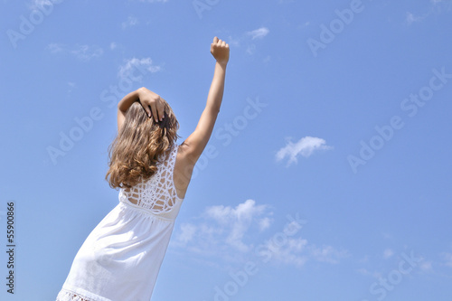 hand of a young girl on a background of the sky greets the new d