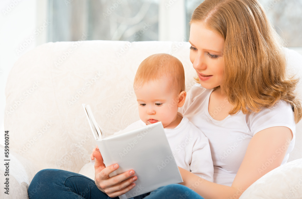 Mother reading a book a little baby on the sofa Mother reading a book a little baby on the sofa