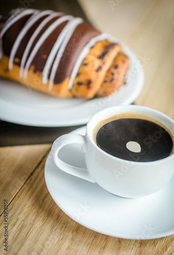 Chocolate bun with cup of coffee