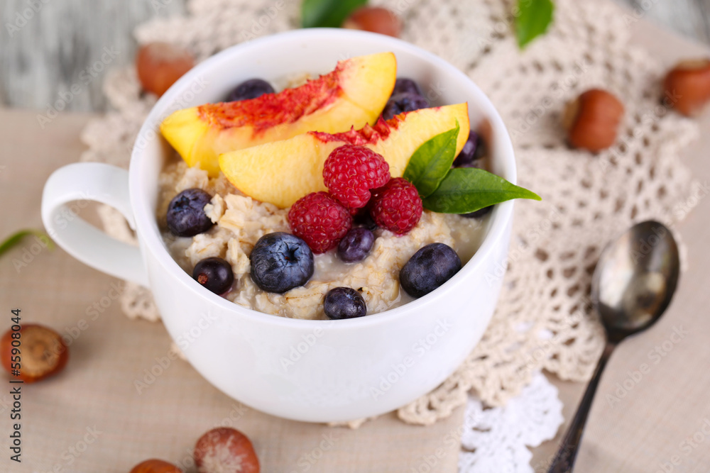 Oatmeal in cup with berries on napkins on wooden table Oatmeal in cup with berries on napkins on wooden table