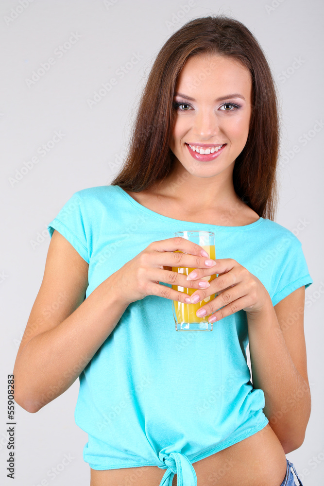 Beautiful girl with fresh juice on grey background Beautiful girl with fresh juice on grey background