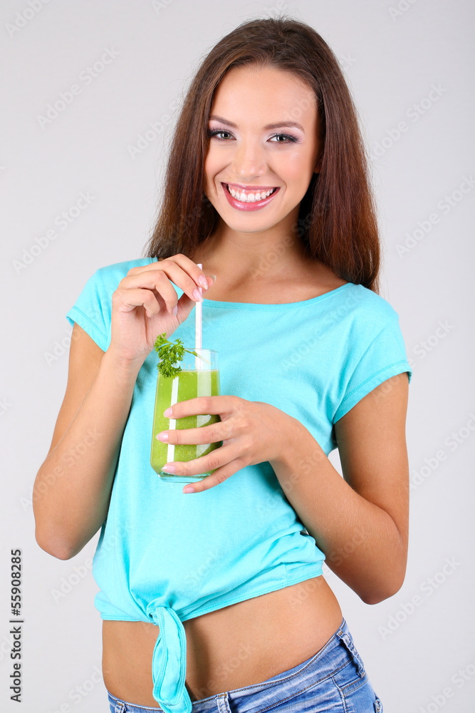 Beautiful girl with fresh juice on grey background Beautiful girl with fresh juice on grey background
