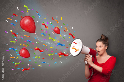 Young girl having fun, shouting into megaphone with balloons