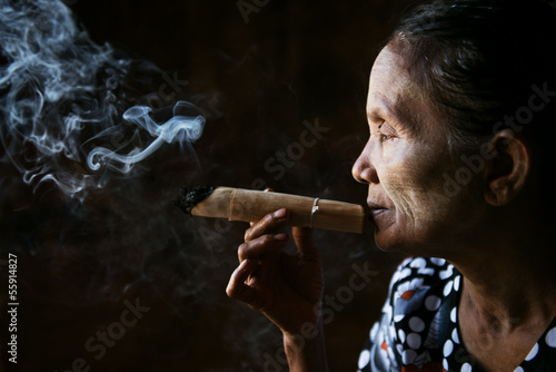 Old wrinkled Asian woman smoking