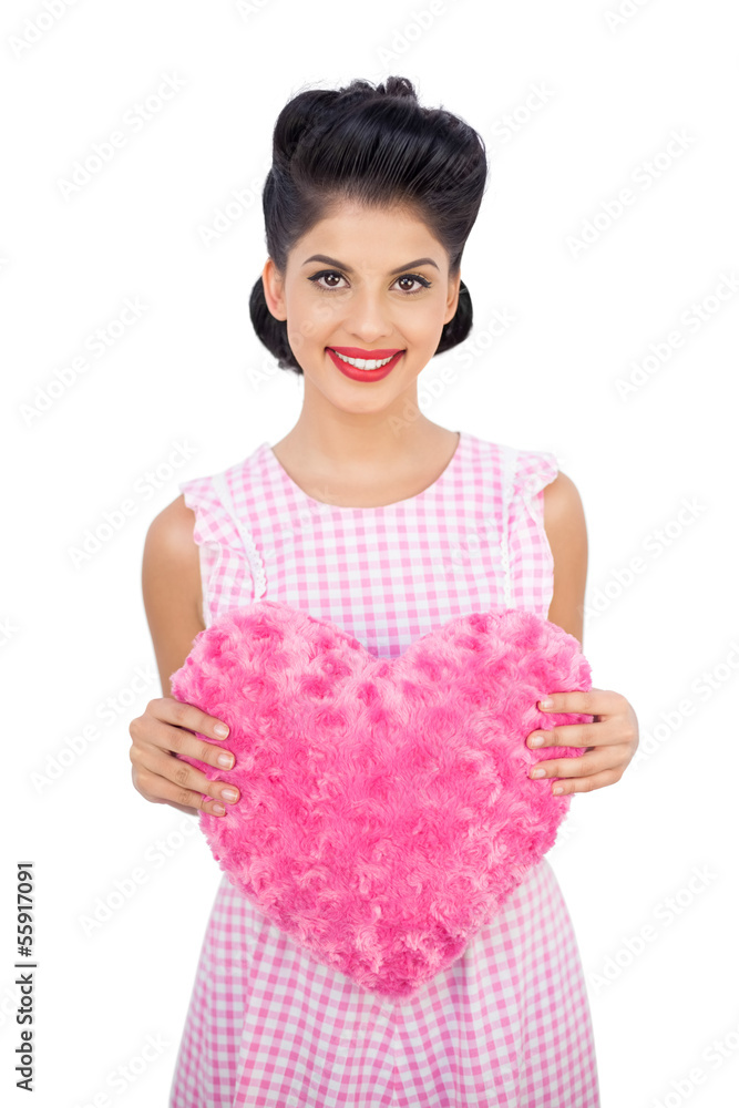 Delighted black hair model holding a pink heart shaped pillow Delighted black hair model holding a pink heart shaped pillow