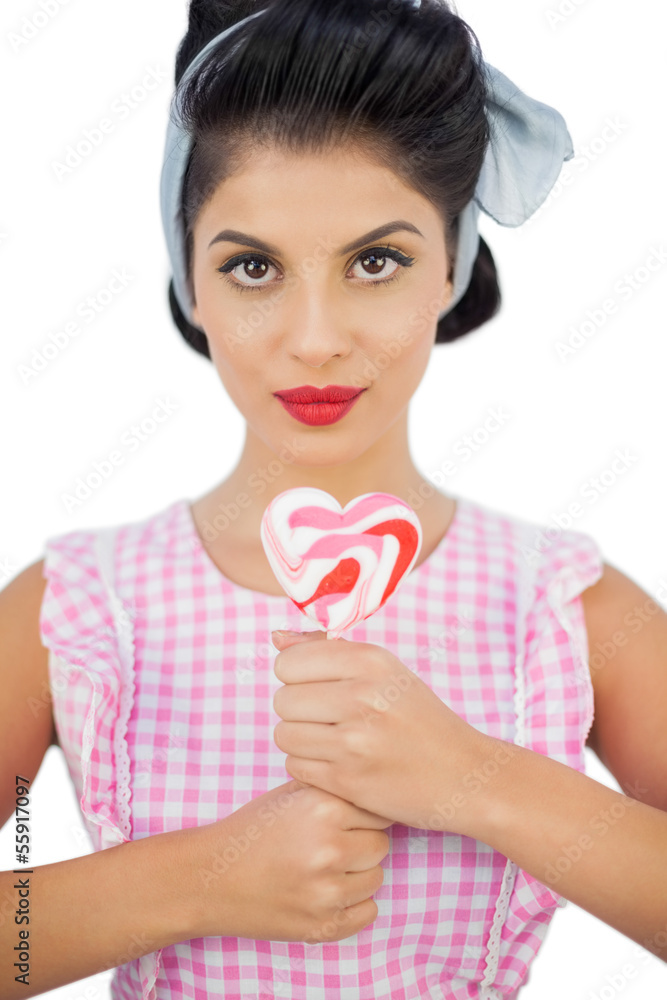 Charming black hair model holding a heart shaped lollipop Charming black hair model holding a heart shaped lollipop