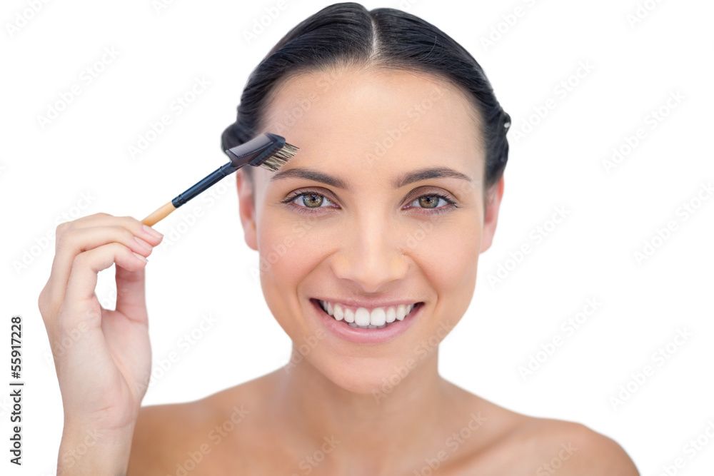 Cheerful young model using eyebrow brush Cheerful young model using eyebrow brush