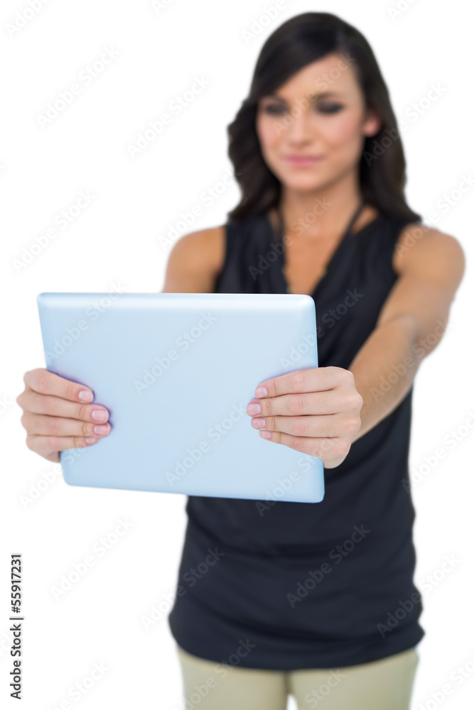 Elegant dark haired model looking at her tablet pc Elegant dark haired model looking at her tablet pc