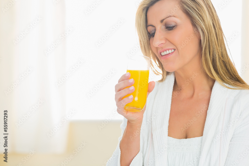 Smiling woman enjoying a glass of orange juice Smiling woman enjoying a glass of orange juice
