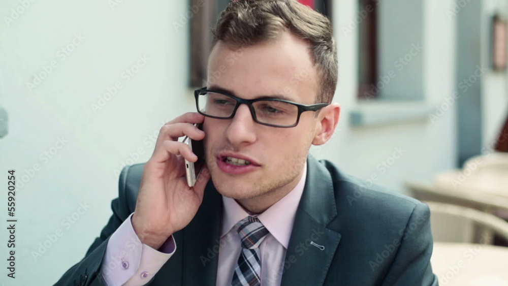 Young handsome businessman talking on mobile phone in cafe Young handsome businessman talking on mobile phone in cafe