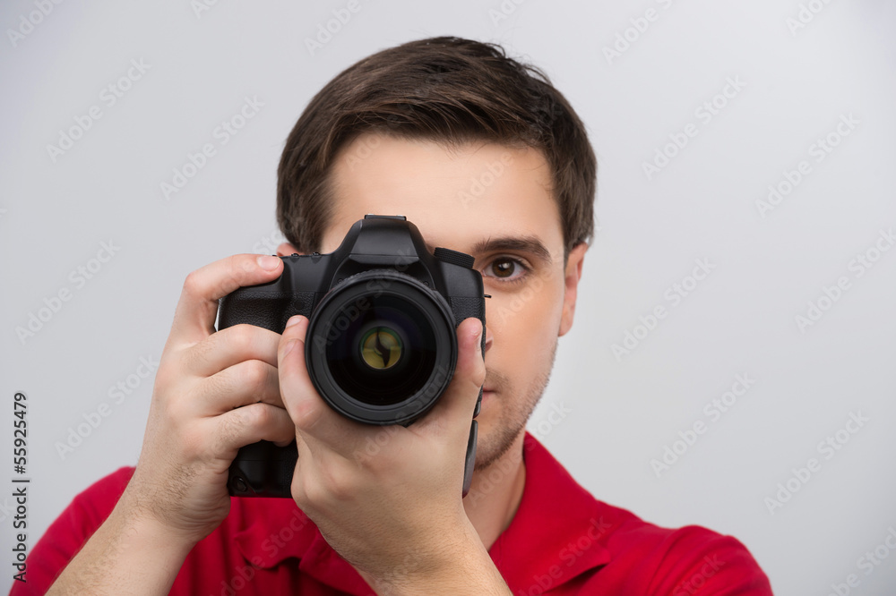 Man with camera. Confident young man holding camera in his hands Man with camera. Confident young man holding camera in his hands