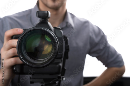 Photographer. Young man holding camera while standing in studio © BlueSkyImages