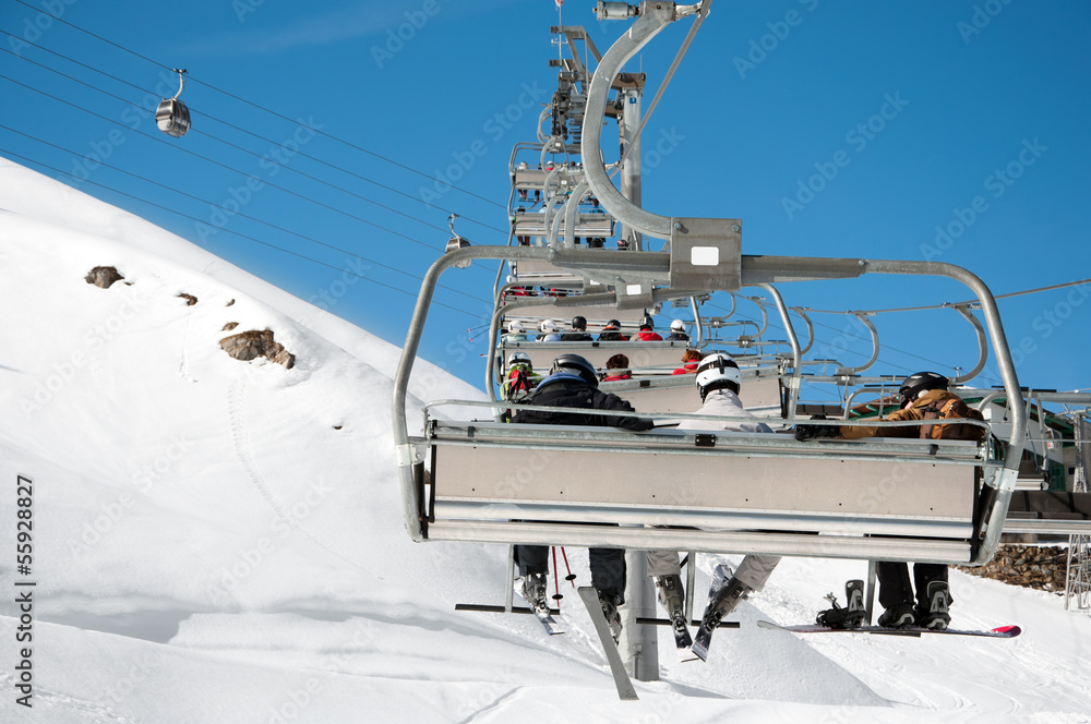 Ski lift working in the alps, with mountains background Ski lift working in the alps, with mountains background