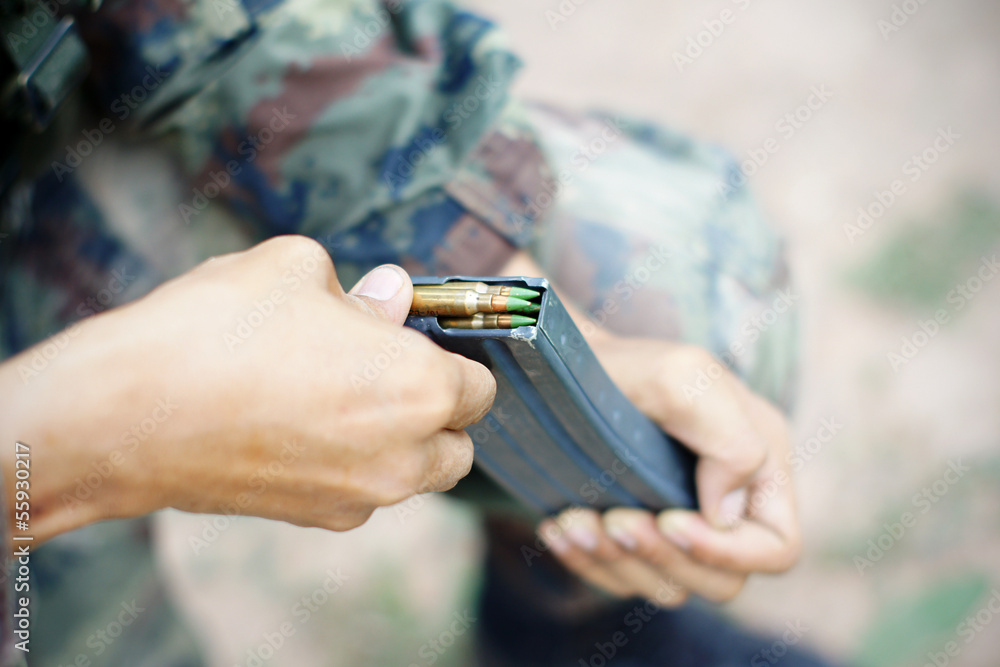 Fototapeta premium inserting ammunition into the cartridge