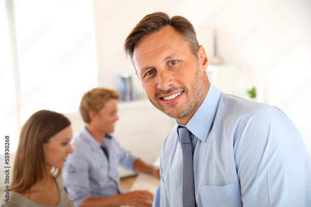 Business manager with employees in background Business manager with employees in background