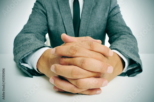 man in suit with clasped hands photo