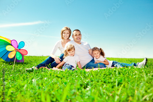 Happy family in outdoor park at sunny day. Mom, dad and two dau