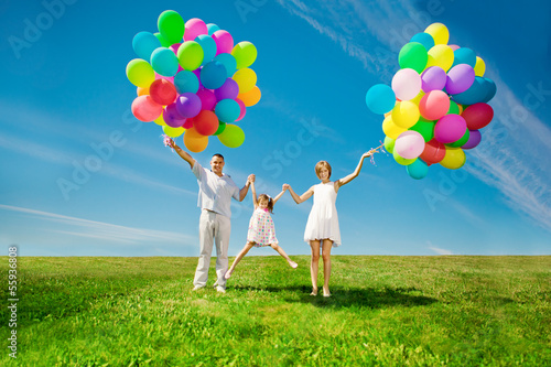 Happy family holding colorful balloons. Mom, ded and two daughte photo