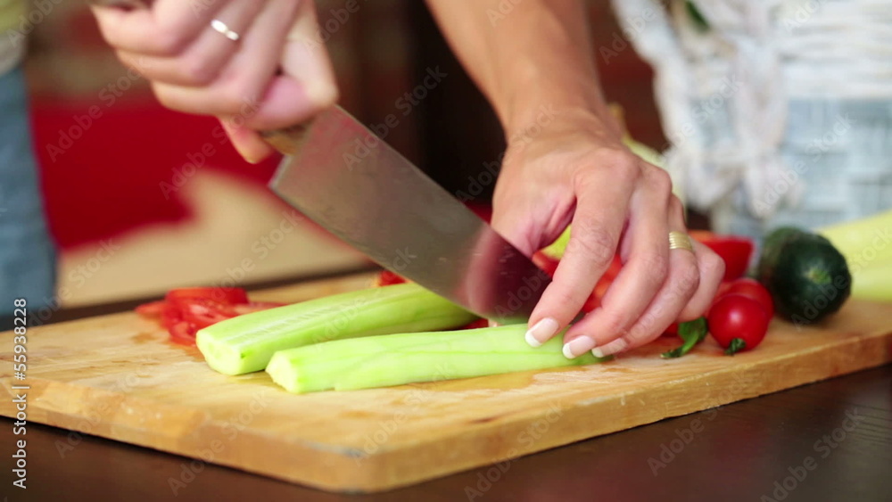 Woman hands slicing, chopping cucumber in kitchen Woman hands slicing, chopping cucumber in kitchen