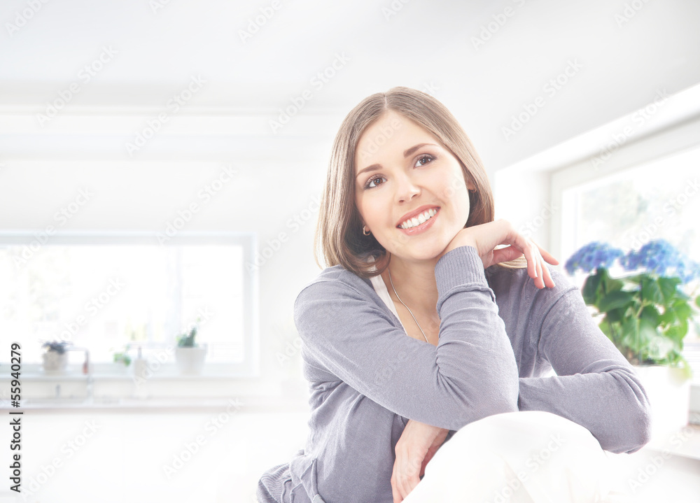 A young and happy brunette woman relaxing on a home interior