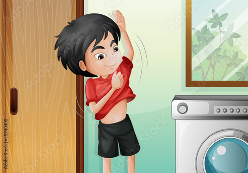 A young boy changing his shirt