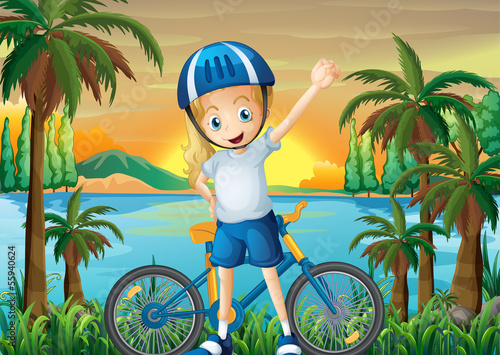 A happy girl and her bike at the riverbank