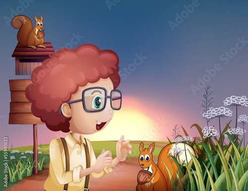 A smart boy at the hilltop with squirrels and an empty signboard