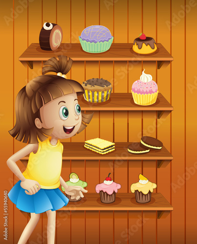 A happy girl in front of the cupcakes and cookies