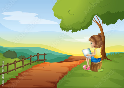 A girl sitting at the stump while using the laptop