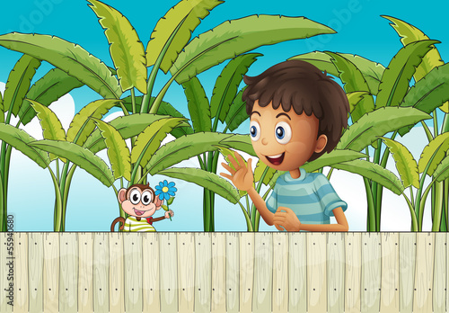 A boy and his monkey near the fence