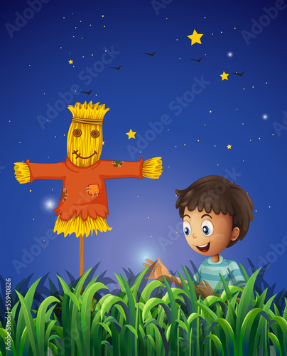 A boy at the farm with a scarecrow