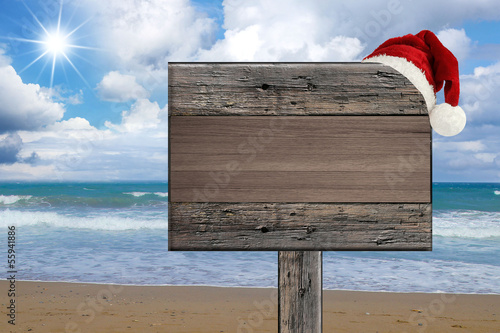 tropical beach wooden signboard with Christmas hat