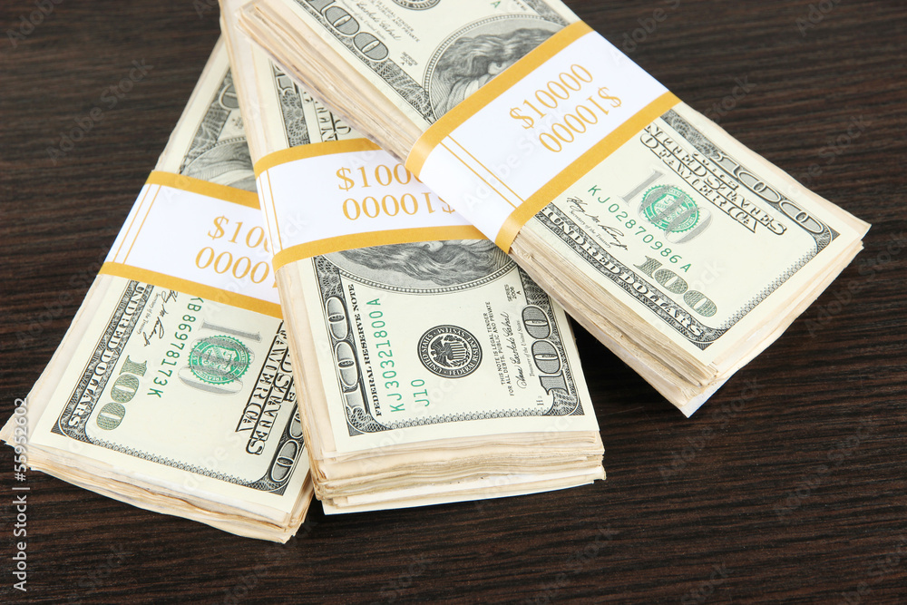 Stacks of money on wooden table Stacks of money on wooden table