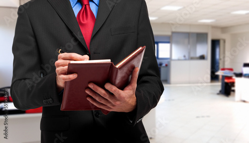 Businessman writing on his agenda