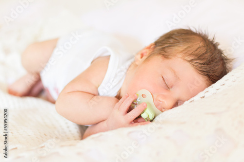 Cute newborn sleeping with pacifier
