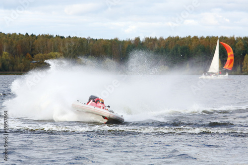 Man fast floats at power boat on river at competitions at autumn