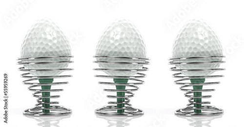 Golf Breakfast - Egg shaped golfballs in in egg cups on a white photo